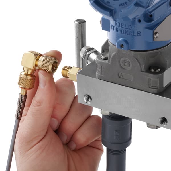 Technician connecting Quick-test 90° elbow adapter (QTHA-HCBL) to a pressure transmitter in a tight space.